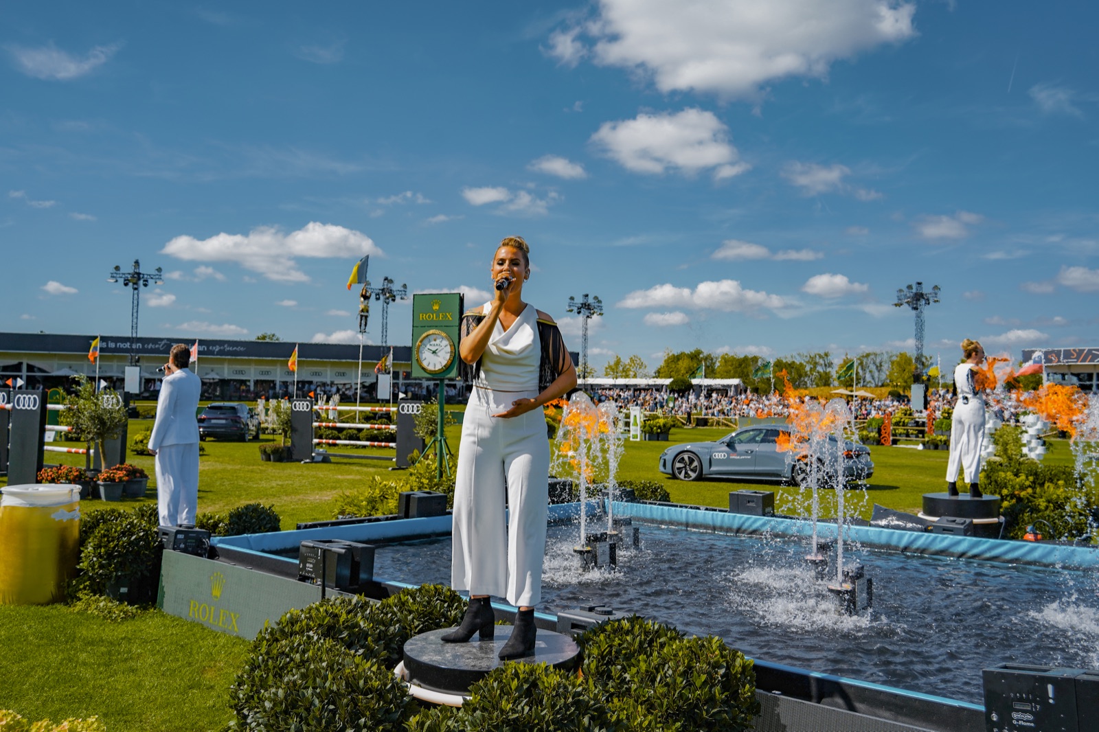 A singer on a platform in a pool of fountains and flames at the Brussels Stephex Masters, 2022