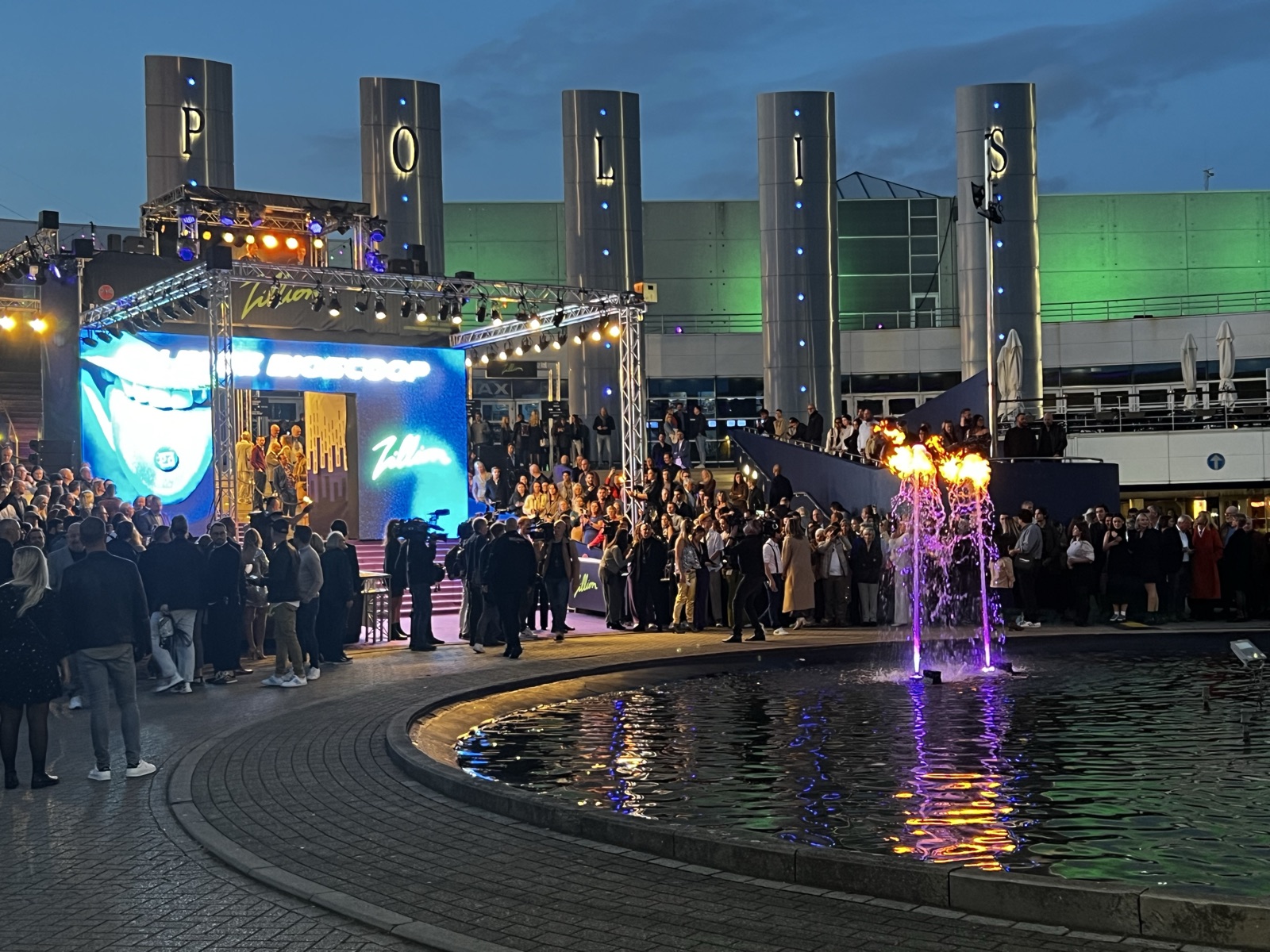 A fountain with a flame in the pond in front of the cinema at the avant-première of Zillion, 2022