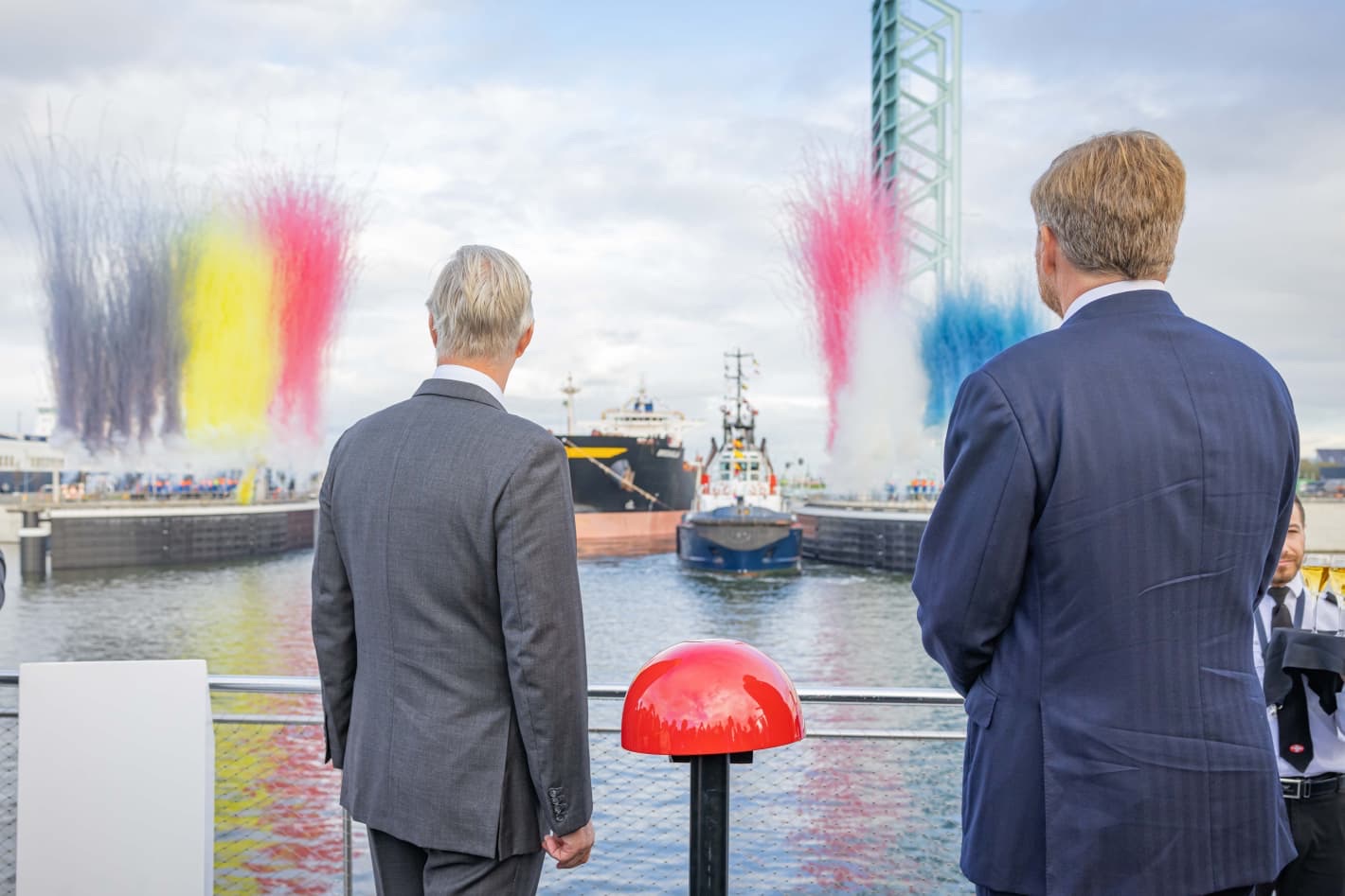 The Belgian and Dutch flags in smoke above the sea lock in Terneuzen, 2024